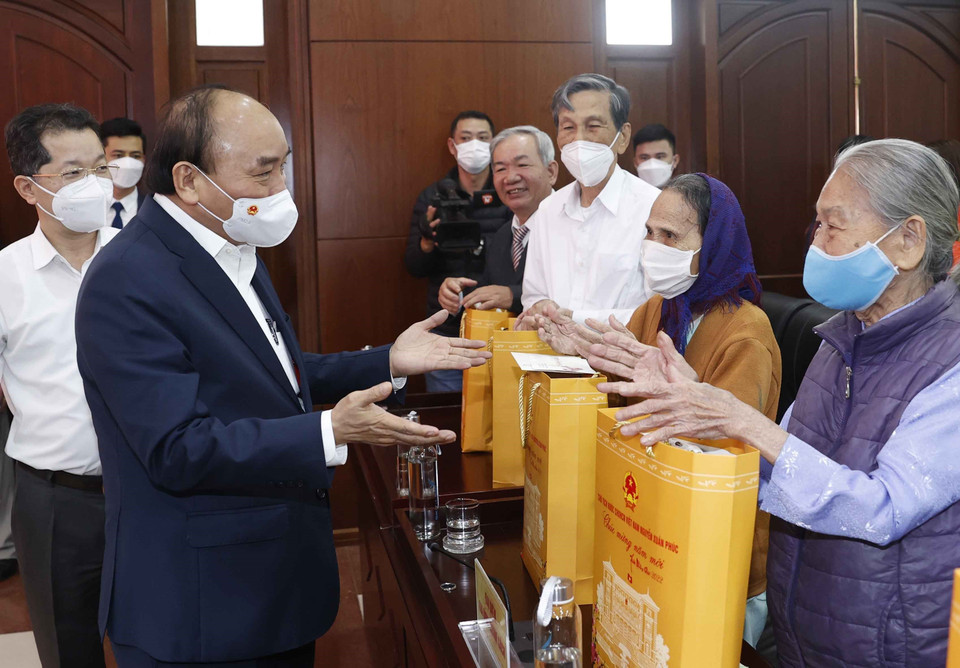 Chủ tịch nước Nguyễn Xuân Phúc trao quà Tết cho đại diện gia đình chính sách, gia đình có công với cách mạng, hộ nghèo, hộ khó khăn do bị ảnh hưởng nặng nề dịch bệnh COVID-19, công nhân, người lao động, người bị ảnh hưởng chất độc da cam/ dioxin trên địa bàn thành phố Đà Nẵng. (Ảnh: Thống Nhất/TTXVN)