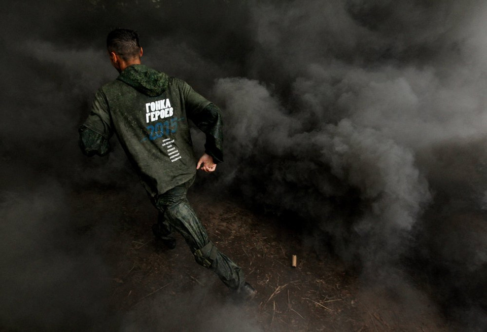 Một thí sinh của cuộc thi thực hiện nhiệm vụ đi qua màn khói đen. (Nguồn: Sputniknews)