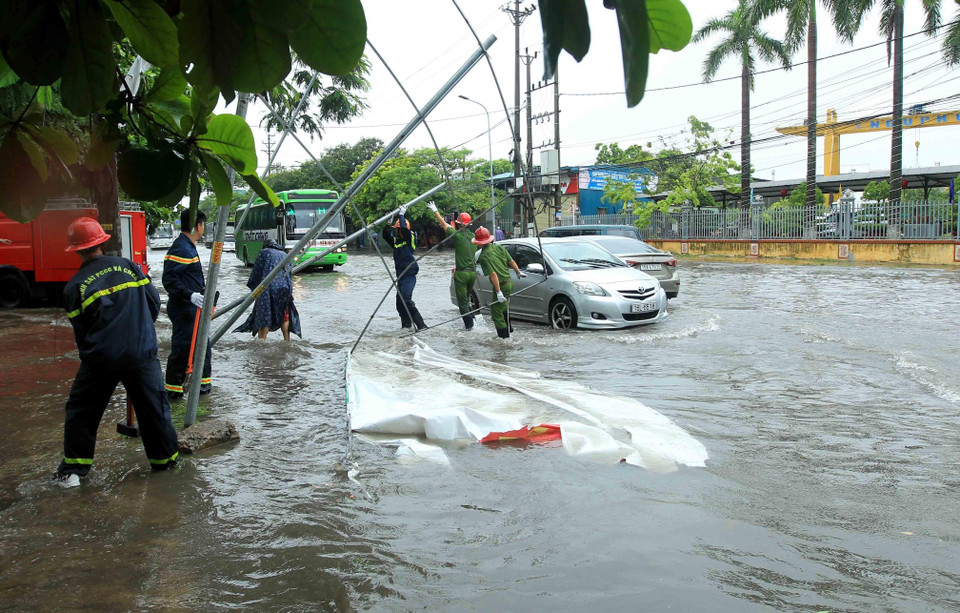 Biển quảng cáo bị đổ, đường phố bị ngập cục bộ, gây ảnh hưởng đến các phương tiện tham gia giao thông ở Hải Phòng. (Ảnh: An Đăng/TTXVN)