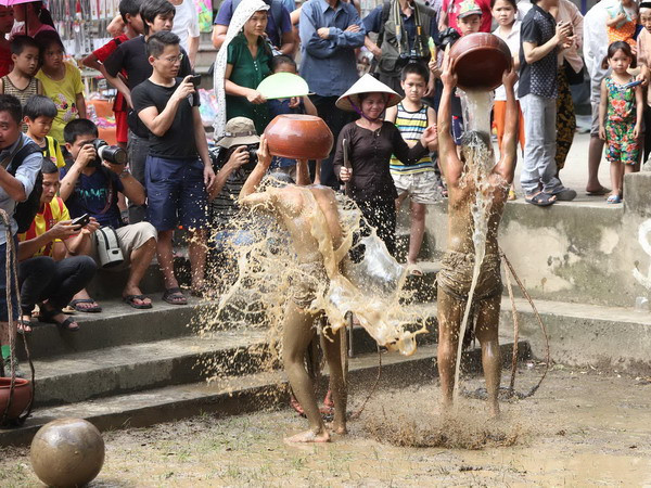 Nước được các phụ nữ gánh từ sông Đuống về sân vật, vừa để tăng lượng nước trong sân cầu, vừa để dội quân cầu giữa hai trận đấu. (Ảnh: Anh Tuấn/TTXVN) Nh