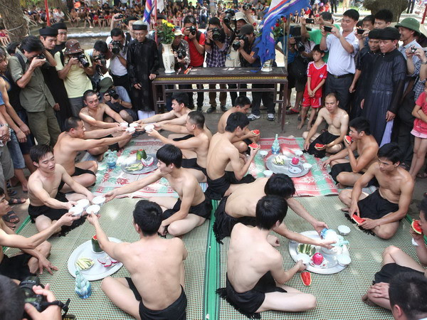 Trước khi vào trận, uống một bình rượu lấy khí thế và ăn một quả dưa hấu để nhận may mắn. (Ảnh: Anh Tuấn/TTXVN)