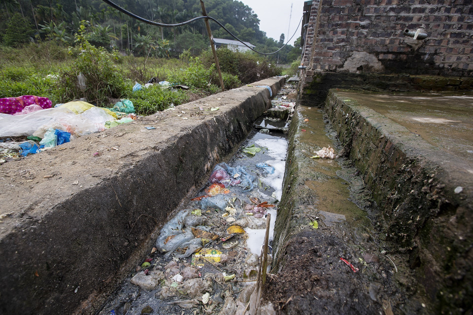 Nước xả thải, nước sinh hoạt từ các khu trọ không được xử lý và đổ thẳng ra sau nhà, ứ đọng bốc mùi gây ô nhiễm nghiêm trọng. (Ảnh: Trọng Đạt/TTXVN)