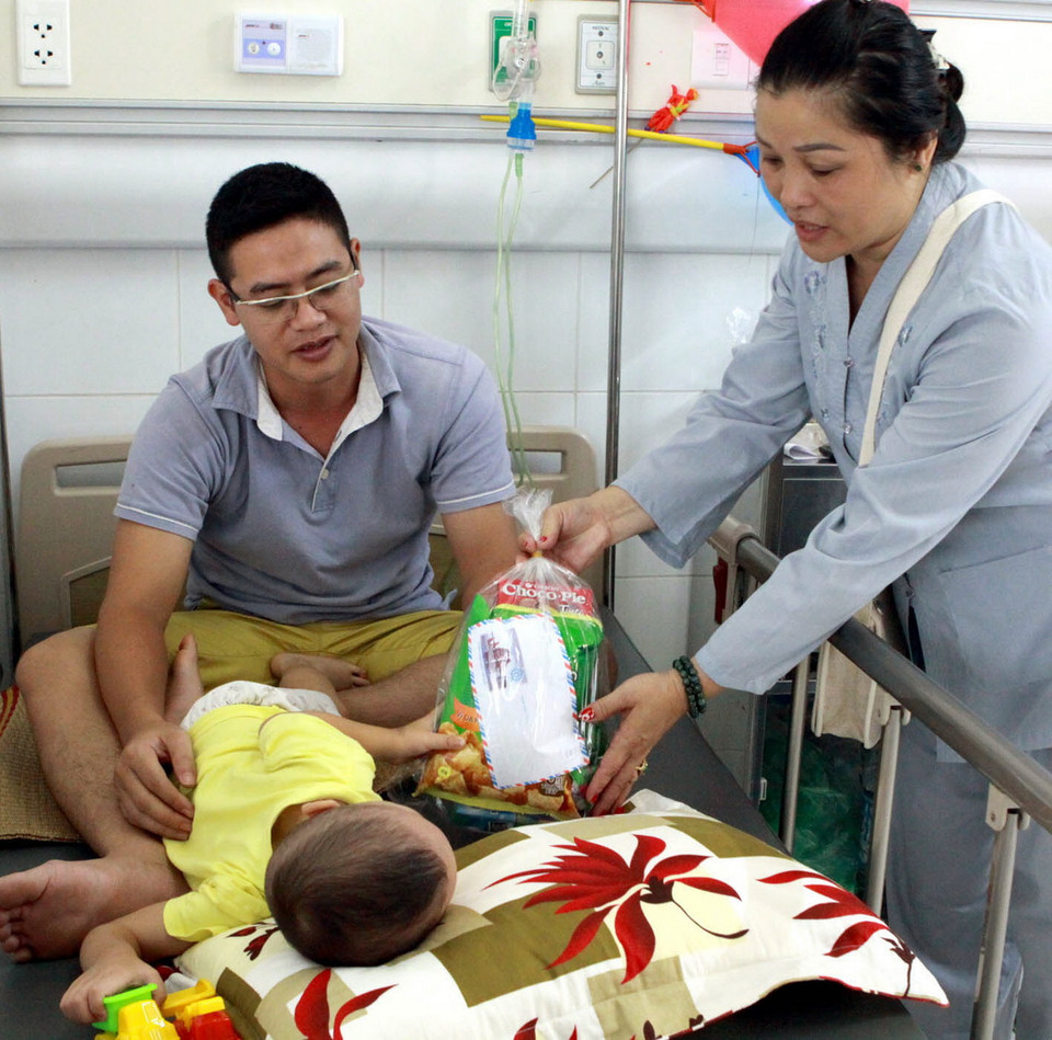 Các nhà hảo tâm tặng quà cho các bệnh nhi. (Ảnh: Dương Ngọc/TTXVN) 