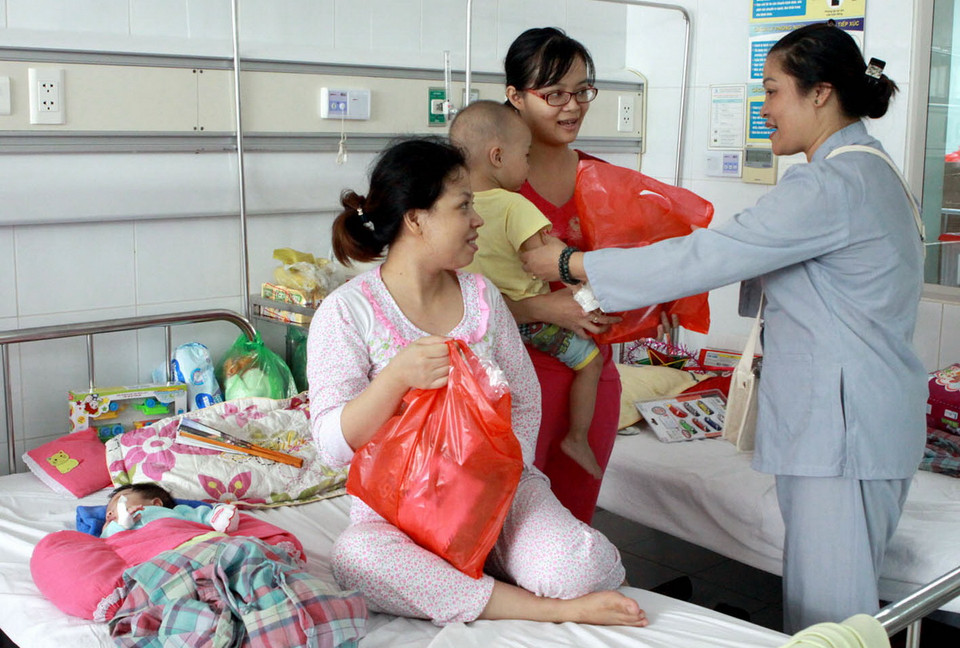 Các nhà hảo tâm tặng quà cho các bệnh nhi. (Ảnh: Dương Ngọc/TTXVN)