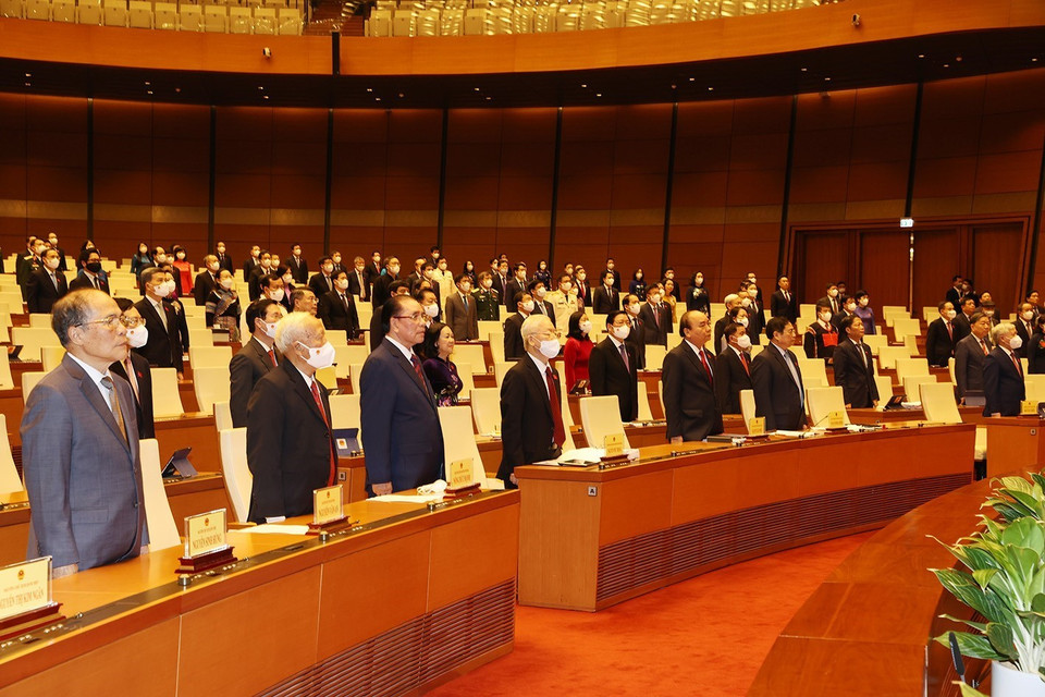 Lãnh đạo, nguyên lãnh đạo Đảng, Nhà nước cùng các đại biểu Quốc hội thực hiện nghi lễ chào cờ khai mạc Kỳ họp thứ 2, Quốc hội khóa XV. (Ảnh: Trí Dũng/TTXVN)