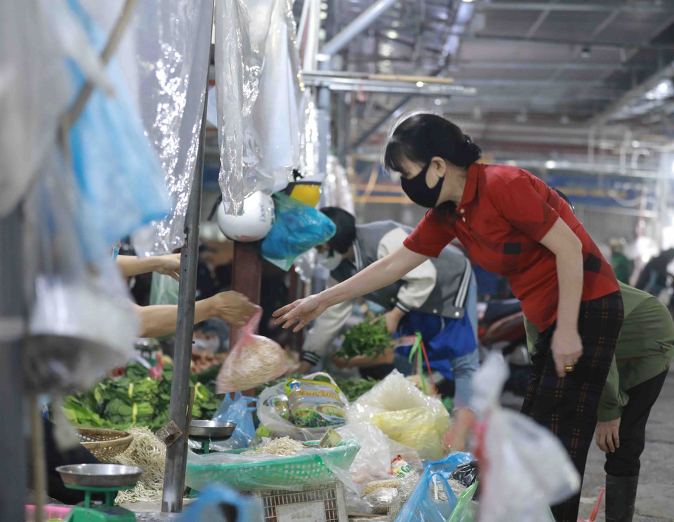 Người mua và người bán thực hiện thông điệp 5K của Bộ Y tế về phòng chống dịch tại chợ Phùng Khoang. (Ảnh: Vũ Sinh/TTXVN)