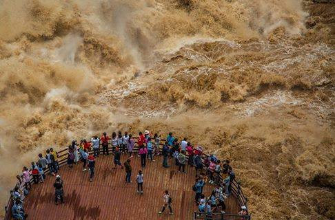 Rất nhiều du khách đã dũng cảm chụp cảnh dòng nước chảy cuồn cuộn ở Khe Hổ Nhảy, nơi dòng sông Dương Tử (Vân Nam, Trung Quốc) chảy qua. (Nguồn: CCTVNews)