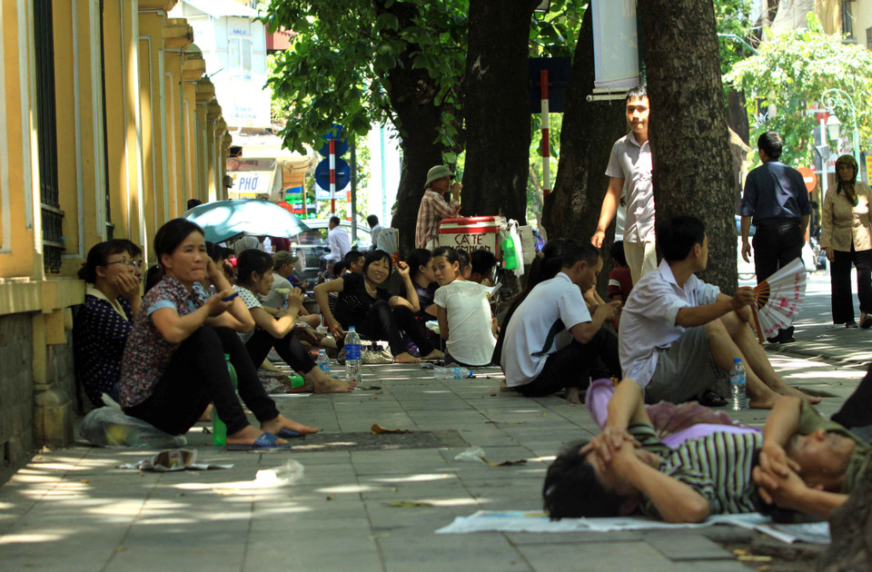 Tại cổng bệnh viện phụ sản Trung ương (Phố Tràng Thi – Hà Nội) những bóng mát là nơi tránh nắng tốt nhất cho người nhà bệnh nhân. (Ảnh: An Đăng/TTXVN) 