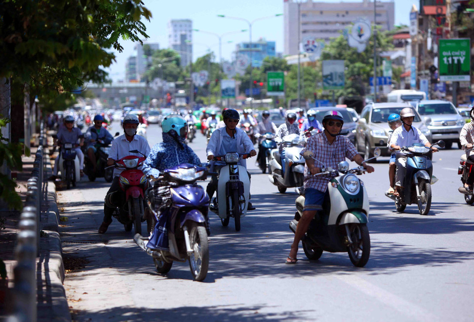 Tán cây trên đường phố Hà Nội được người dân tận dụng triệt để khi dừng chờ đèn tín hiệu giao thông. (Ảnh: Quý Trung/TTXVN)