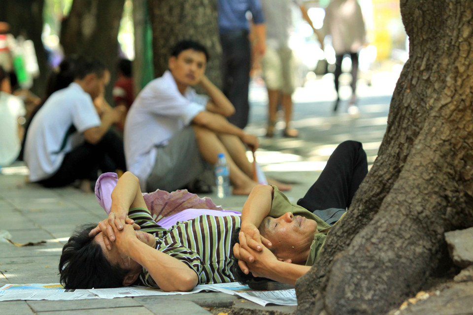 Tại cổng bệnh viện phụ sản Trung ương (Phố Tràng Thi – Hà Nội) những bóng mát là nơi tránh nắng tốt nhất cho người nhà bệnh nhân. (Ảnh: An Đăng/TTXVN) 