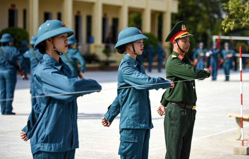 Giáo viên hướng dẫn các động tác trong diễu hành cho các nữ dân quân tự vệ Tây Bắc. (Ảnh: Trung Kiên/TTXVN)