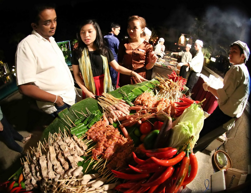 Khách du lịch tham quan và thưởng thức ẩm thực tại phiên Chợ quê ngày Tết xưa. (Ảnh: Trần Lê Lâm/TTXVN) 