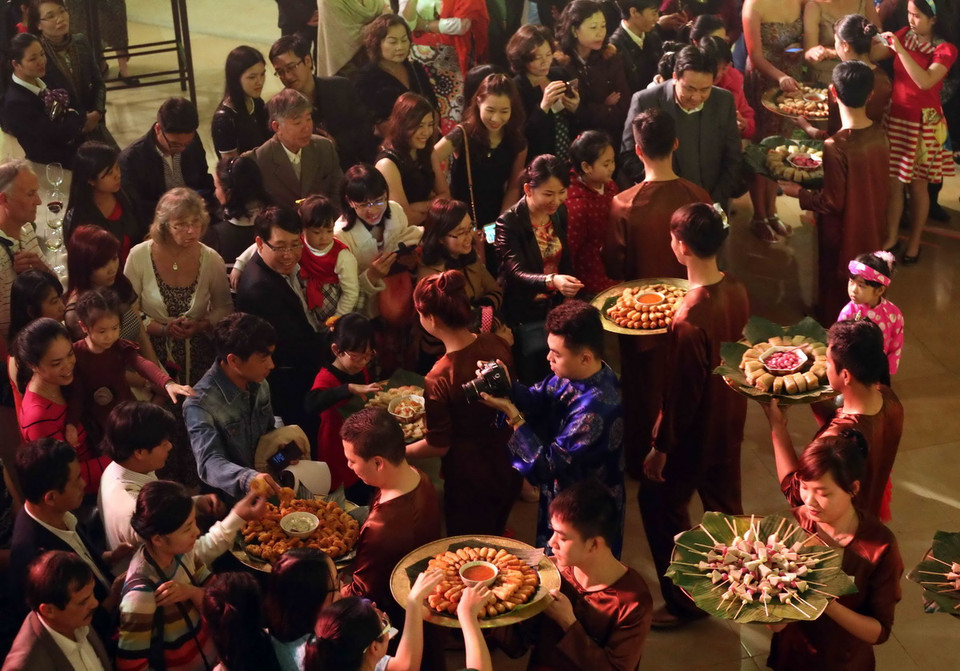 Khách du lịch tham quan và thưởng thức các món ăn ngày Tết xưa tại phiên chợ. (Ảnh: Trần Lê Lâm/TTXVN) 