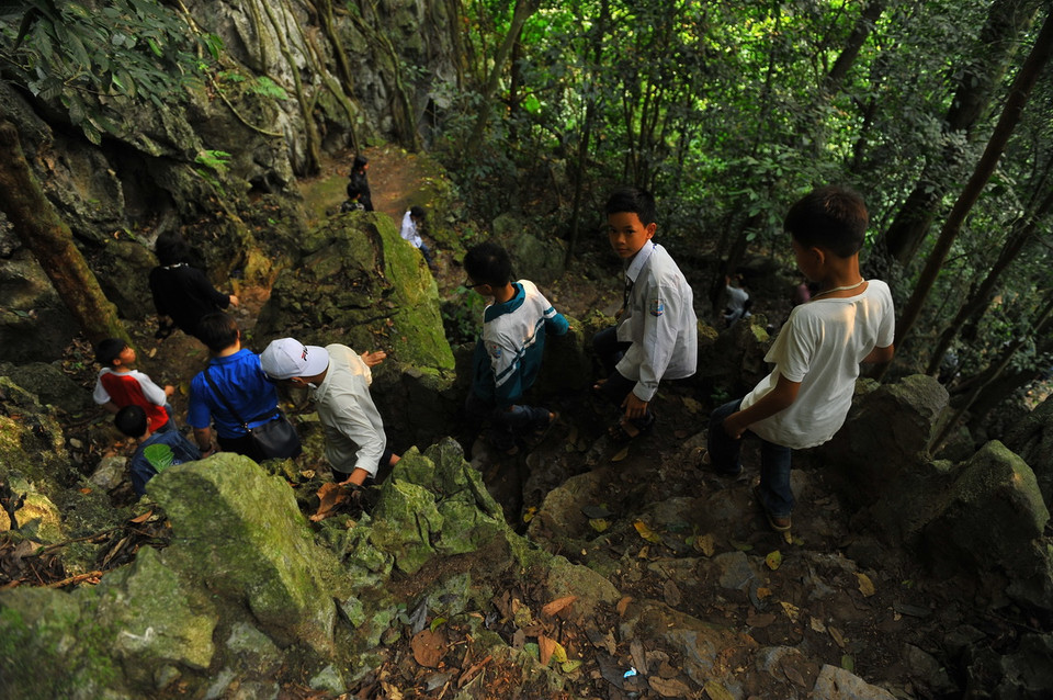 Đến thăm động Người Xưa, từ cửa rừng Cúc Phương khoảng 4km, du khách đi bộ trên cây cầu dài hơn 100m đến chân dãy núi đá vôi và leo lên với độ cao khoảng 50m, vượt qua trên 200 bậc đá. (Ảnh: Minh Đức/TTXVN)