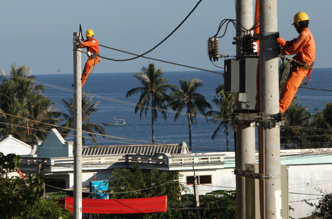 Triển khai xây dựng lưới điện phân phối, lắp đặt côngtơ điện tử, đưa điện đến từng hộ dân. (Ảnh: Ngọc Hà/TTXVN)