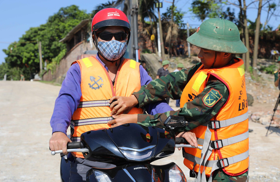 Lực lượng quân đội hướng dẫn, hỗ trợ người dân khi tham gia lưu thông qua phà, đảm bảo đúng cách. (Ảnh: Tạ Toàn/TTXVN)