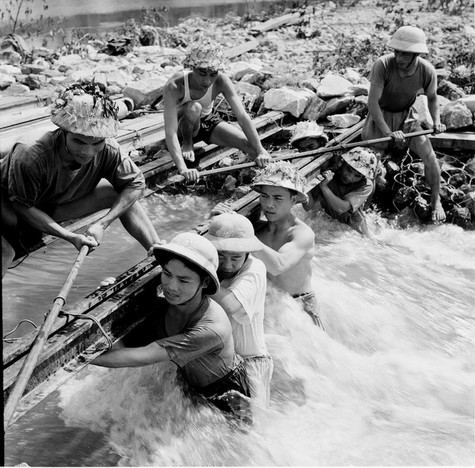 Chiến sỹ công binh vật lộn với dòng nước xiết để bắc cầu cho xe vào chiến trường. (Ảnh: Văn Sắc/TTXVN)