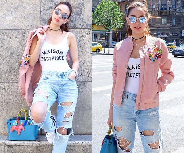 Cũng có mặt tại Budapest trong tuần vừa rồi, Minh Hằng ghi điểm tuyệt đối với người hâm mộ khi 'chơi trội' cùng bộ đồ phối theo công thức layer. Nữ diễn viên đa tài mix áo sát nách dáng ôm và quần jeans rách bụi phủi, bên ngoài là áo khoác màu hồng phấn. Cô càng sành điệu hơn khi điểm thêm cặp phụ kiện vòng cổ choker và kính mắt tráng gương hợp mốt.