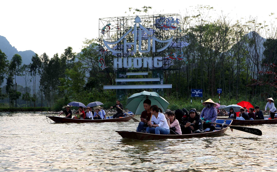 Dòng thuyền trở du khách tấp nập trên dòng suối Yến. (Ảnh: Thanh Tùng/TTXVN)