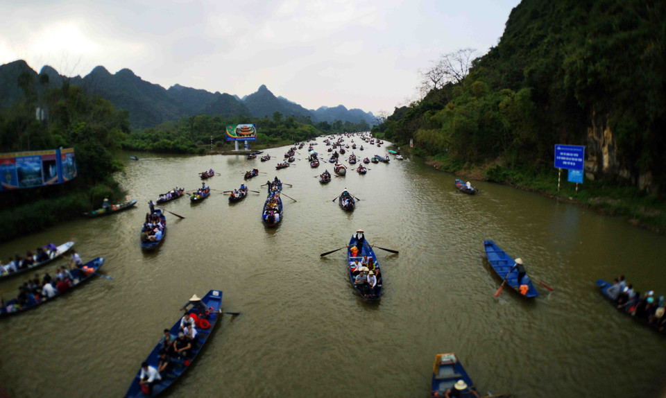 Dòng thuyền trở du khách tấp nập trên dòng suối Yến. (Ảnh: Thanh Tùng/TTXVN)