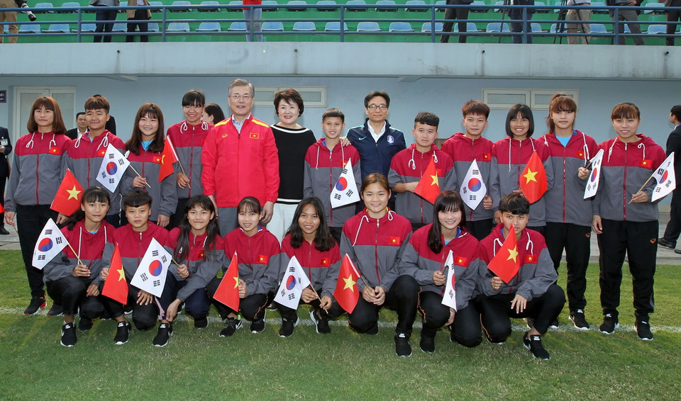 Tổng thống Hàn Quốc Moon Jae-in và Phu nhân cùng Phó Thủ tướng Vũ Đức Đam chụp ảnh chung với các cầu thủ trẻ của Trung tâm Đào tạo bóng đá trẻ Việt Nam. (Ảnh: Quốc Khánh/TTXVN)