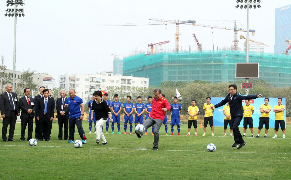Tổng thống Hàn Quốc Moon Jae-in (giữa, áo đỏ), Phu nhân (bên trái) và Phó Thủ tướng Vũ Đức Đam (bên phải) trổ tài đá bóng trong buổi giao lưu với các tuyển thủ U23 Việt Nam. (Ảnh: Quốc Khánh/TTXVN)