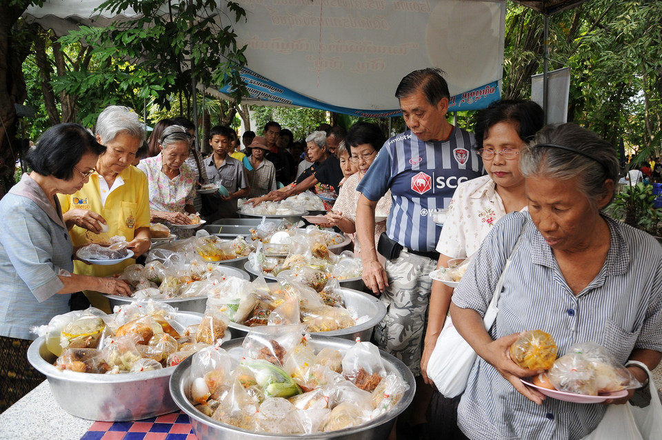 Kết thúc lễ cúng dường, các Phật tử sẽ chia nhau đồ ăn mà các chư Tăng chưa dùng đến. Một phần sẽ được đem chia cho các trẻ em nghèo, mồ côi, tàn tật, có hoàn cảnh khó khăn. (Ảnh: Sơn Nam-Quang Thuận/Vietnam+)