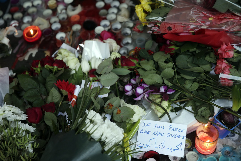 Thắp nến và đặt hoa tưởng niệm các nạn nhân vụ tấn công khủng bố tại lối vào quán cafe 'La Belle Equipe' ở Paris, Pháp ngày 15/11. (Nguồn: AFP/TTXVN)