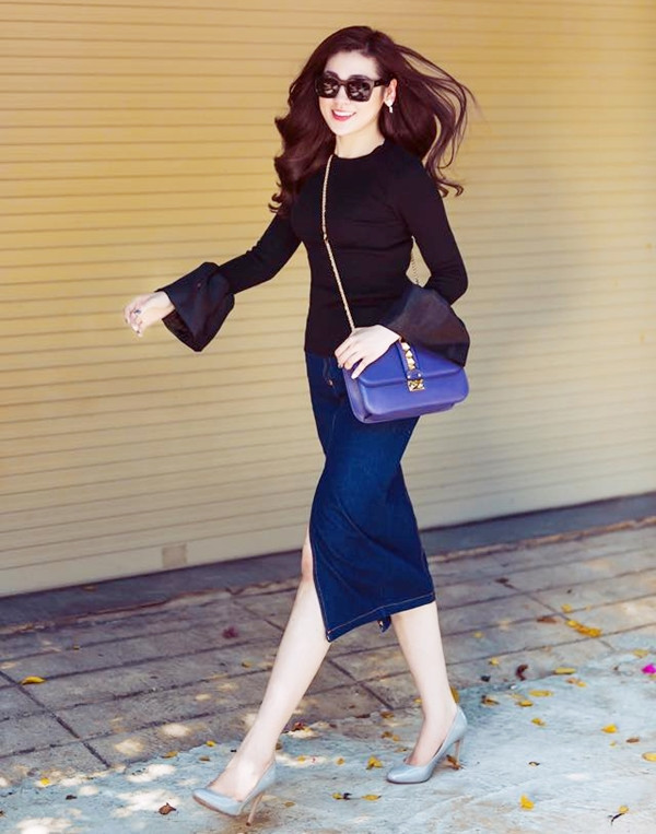 Á hậu Tú Anh rạng rỡ trong bộ cánh tối màu. Người đẹp khéo léo lăng xê xu hướng áo tay chuông, kết hợp chân váy denim xẻ tà và giày cao gót gam màu ghi nhã nhặn.