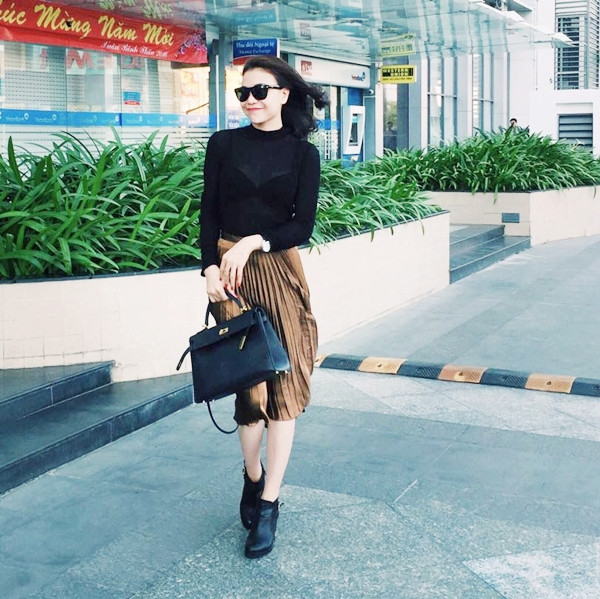 Phối áo xuyên thấu cùng chân váy midi (váy dài qua đầu gối) xếp li nhẹ nhàng, Trà Ngọc Hằng không quên chấm phá cá tính bằng đôi bốt da thấp cổ.