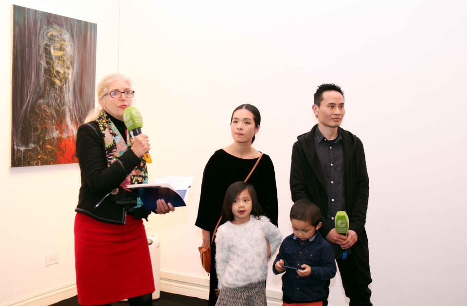 Bà Almuth Meyer – Zollitsch (Viện trưởng Viện Goethe Việt Nam) giới thiệu hai tác giả của buổi triển lãm là Dương Thùy Dương (áo đen, ở giữa) và Đỗ Tuấn Anh (ngoài cùng bên phải). (Ảnh: Doãn Đức/Vietnam+)