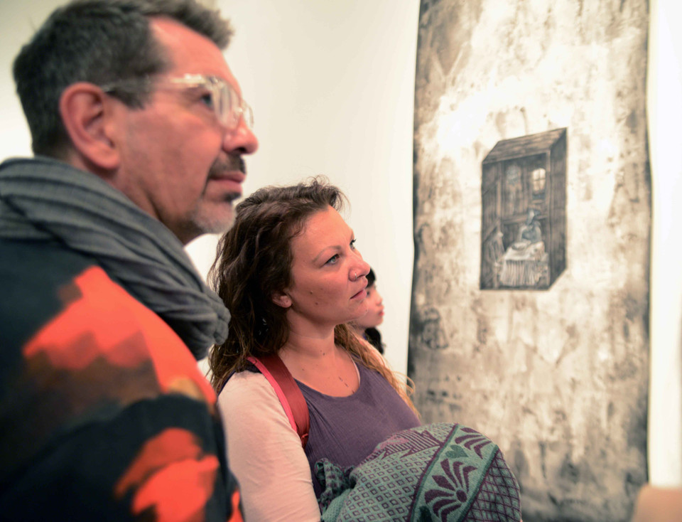 Du khách nước ngoài chăm chú thưởng thức các tác phẩm. (Ảnh: Ngọc Tùng/Vietnam+)