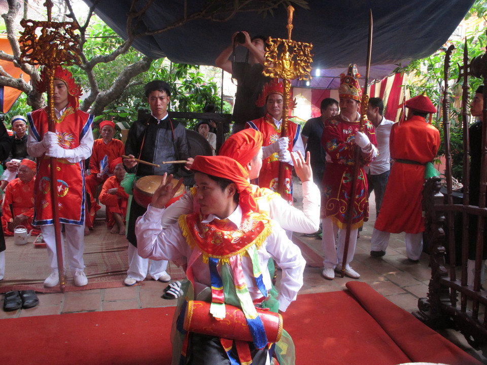 Những người tới xem chắc hẳn sẽ không khỏi bất ngờ khi chứng kiến những chàng trai đánh phấn bôi son, mặc áo mớ ba mớ bảy múa ở sân đình. Chẳng những thế, họ còn còn liếc mắt đưa tình, trao cho nhau những cử chỉ tình tứ không khác gì những cô gái thực thụ. (Ảnh: Tiến Đạt/Vietnam+)