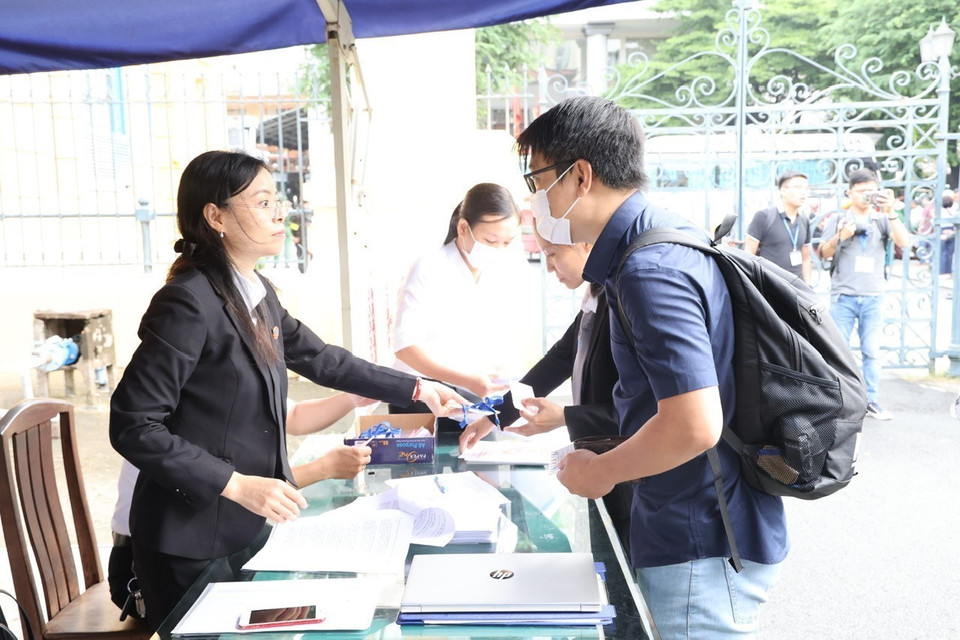 Các phóng viên làm thủ tục tham dự phiên khai mạc. (Ảnh: Thanh Vũ/TTXVN)