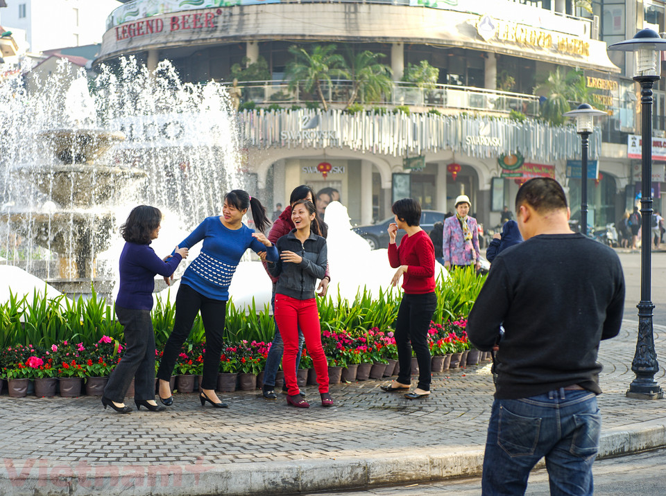 Phải tới gần trưa, người Hà Nội mới rủ nhau ra đường ghi lại những khoảnh khắc năm mới. (Ảnh: Hoàng Long-Võ Phương/Vietnam+)
