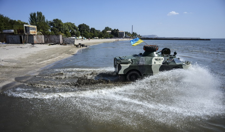 Binh sỹ Ukraine thực hiện kỹ năng đổ bộ trên bãi biển Mariupol trong khuôn khổ tập trận. (Nguồn: AFP/TTXVN)