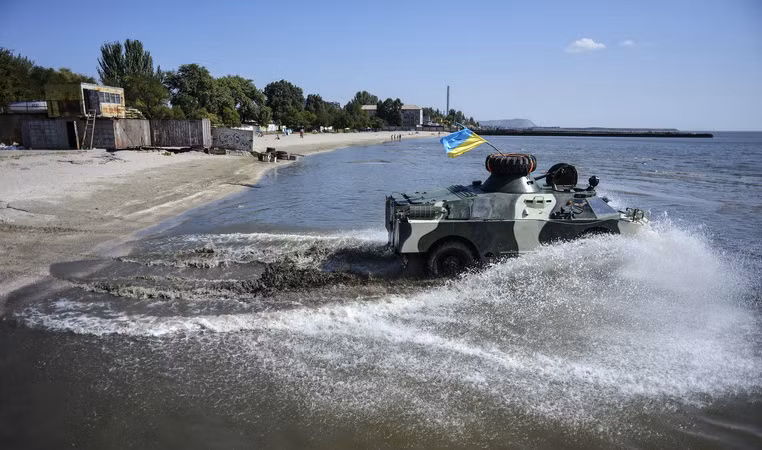 Binh sỹ Ukraine thực hiện kỹ năng đổ bộ trên bãi biển Mariupol trong khuôn khổ tập trận. (Nguồn: AFP/TTXVN)