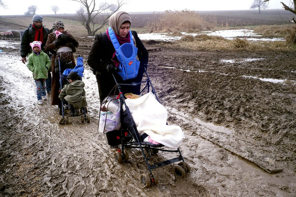 Bà mẹ đẩy xe trên đường bùn lầy lội khi vào địa phận Serbia. (Nguồn: Getty Images)