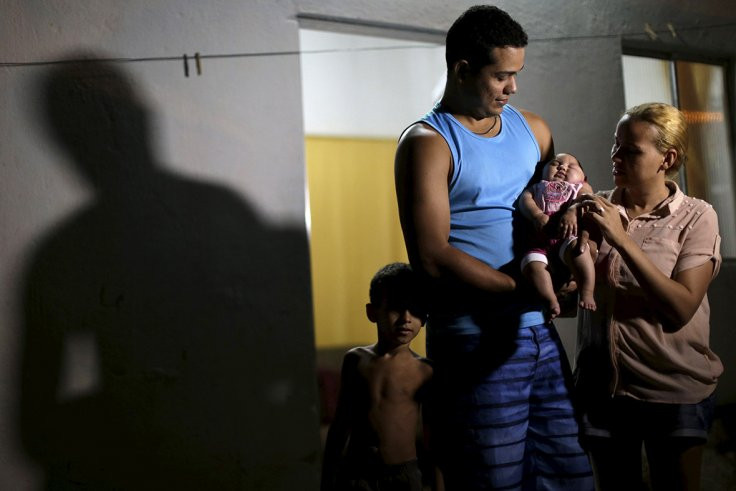 Gia đình Felipe và Gleyse Kelly đang bế con gái mắc chứng đầu nhỏ. (Nguồn: Reuters)