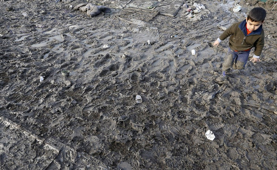 Em bé đang đi trong bùn ở trại tị nạn. (Nguồn: Reuters)