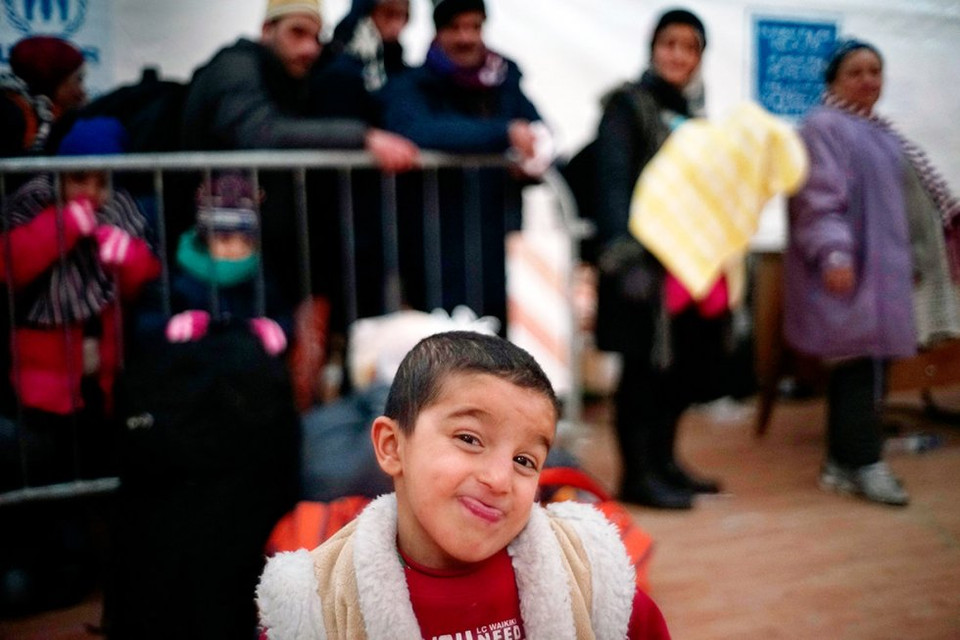 Một em bé Afghanistan tạo dáng ở khu vực tiếp nhận hồ sơ, nơi đây quyết định xem những người tị nạn nào mới được lên tàu. (Nguồn: Reuters)