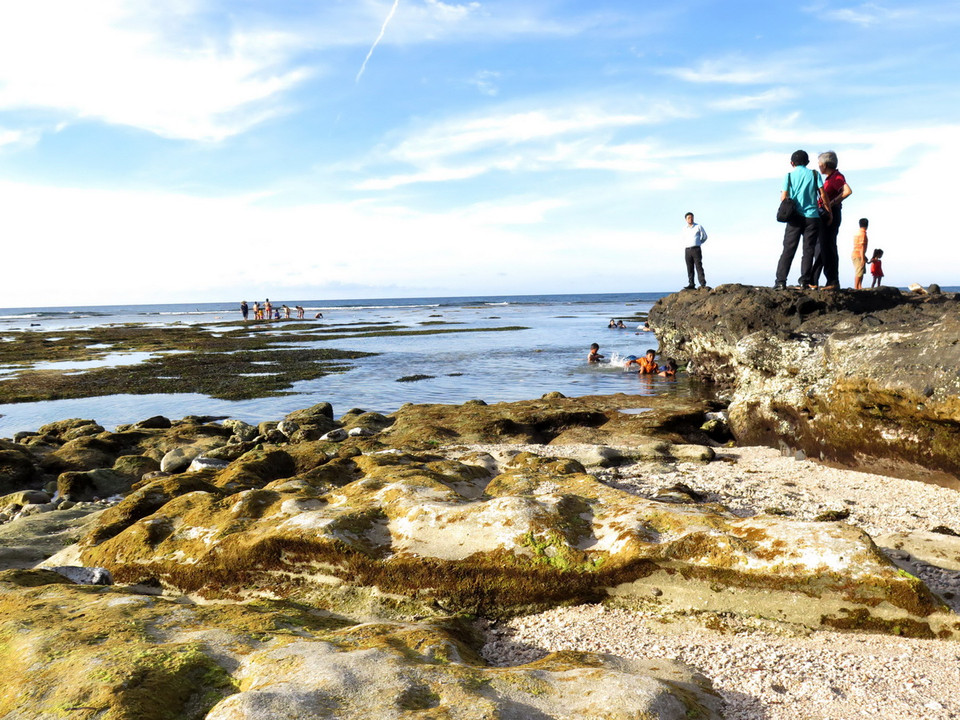 Khi thủy triều rút, địa mạo bờ biển lộ thiên những dấu tích độc lạ của dung nham hóa đá hòa lẫn với dải vàng óng của rong biển dưới ánh trời hoàng hôn càng khiến cho hang Câu thêm phần lý thú, cuốn hút người xem. (Ảnh: Phước Ngọc/TTXVN) 