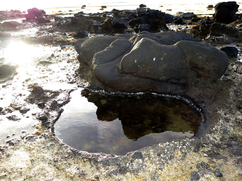 Trầm tích dung nham dưới sự bào mòn của nước biển tạo nên những hố nhỏ trông như những giếng nước. (Ảnh: Phước Ngọc/TTXVN) 