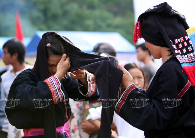 Một trong số các công đoạn mất nhiều thời gian nhất trong quy trình mặc trang phục của người phụ nữ Dao Tiền là quấn khăn đầu. Chiếc khăn đầu có chiều dài khoảng 3m được quần nhiều vòng như chiếc mũ. (Ảnh: Thông Thiện/Báo ảnh Việt Nam)