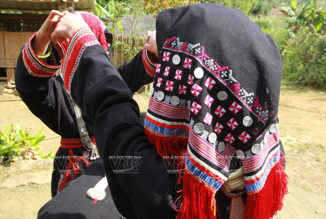 Trên chiếc khăn quấn đầu của người phụ nữ Dao Tiền thường có những đồng tiền bằng bạc trang trí. Theo quan niệm của người Dao Tiền, những đồng tiền bạc được gắn trên khăn sẽ mang lại nhiều của cải. (Ảnh: Thông Thiện/Báo ảnh Việt Nam)