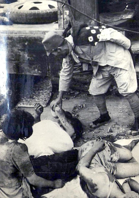 Người dân địa phương đi dọc phố, bên cạnh là các thi thể. (Nguồn: Dailymail)