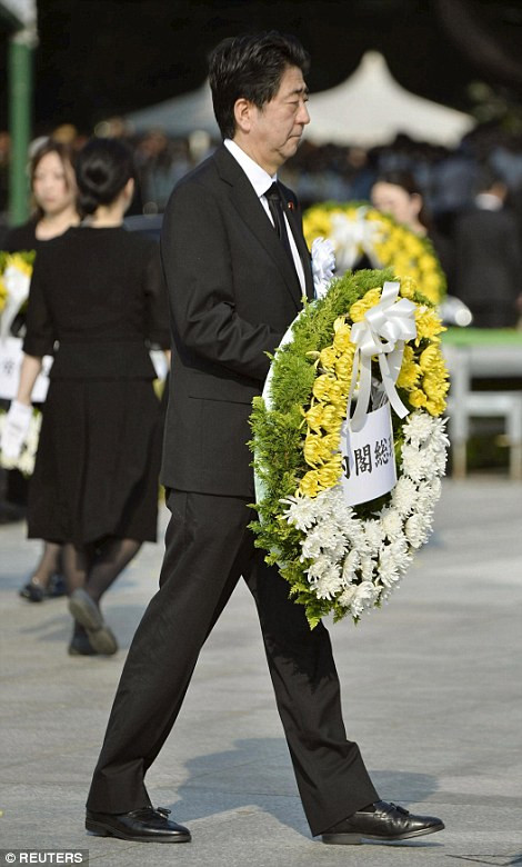 Thủ tướng Nhật bản Shinzo Abe mang vòng hoa tưởng nhớ nạn nhân ở đài tưởng niệm. (Nguồn: Dailymail)