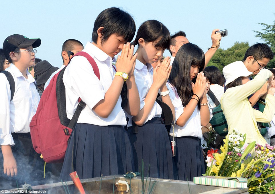 Các nữ sinh Nhật bản thể hiện lòng thành kính đối với các nạn nhân Hiroshima trên đường tới trường. (nguồn: Dailymail)