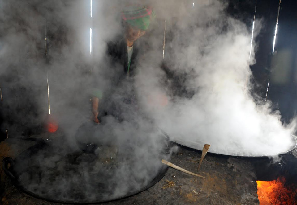 Trong khi nấu, nước mía được đảo cho sôi đều giữa các vạc đựng. (Ảnh: Nguyễn Công Hải/Vietnam+)