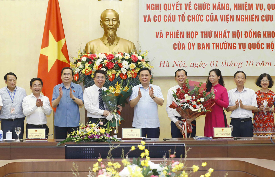 Chủ tịch Quốc hội Vương Đình Huệ trao nghị quyết và tặng hoa chúc mừng lãnh đạo Viện Nghiên cứu lập pháp. (Ảnh: Doãn Tấn/TTXVN)